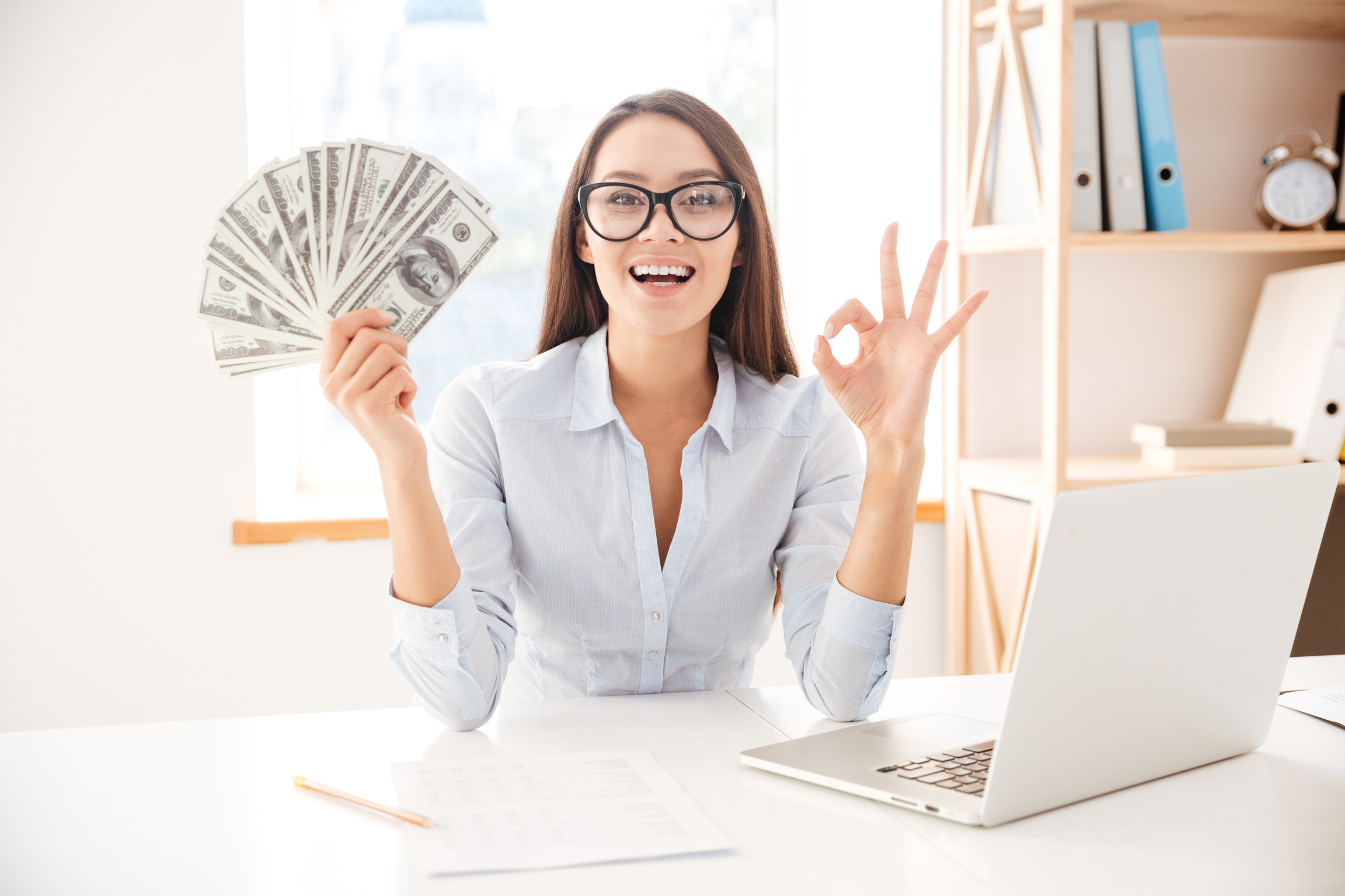 Employee Holding a Fan of Dollars 